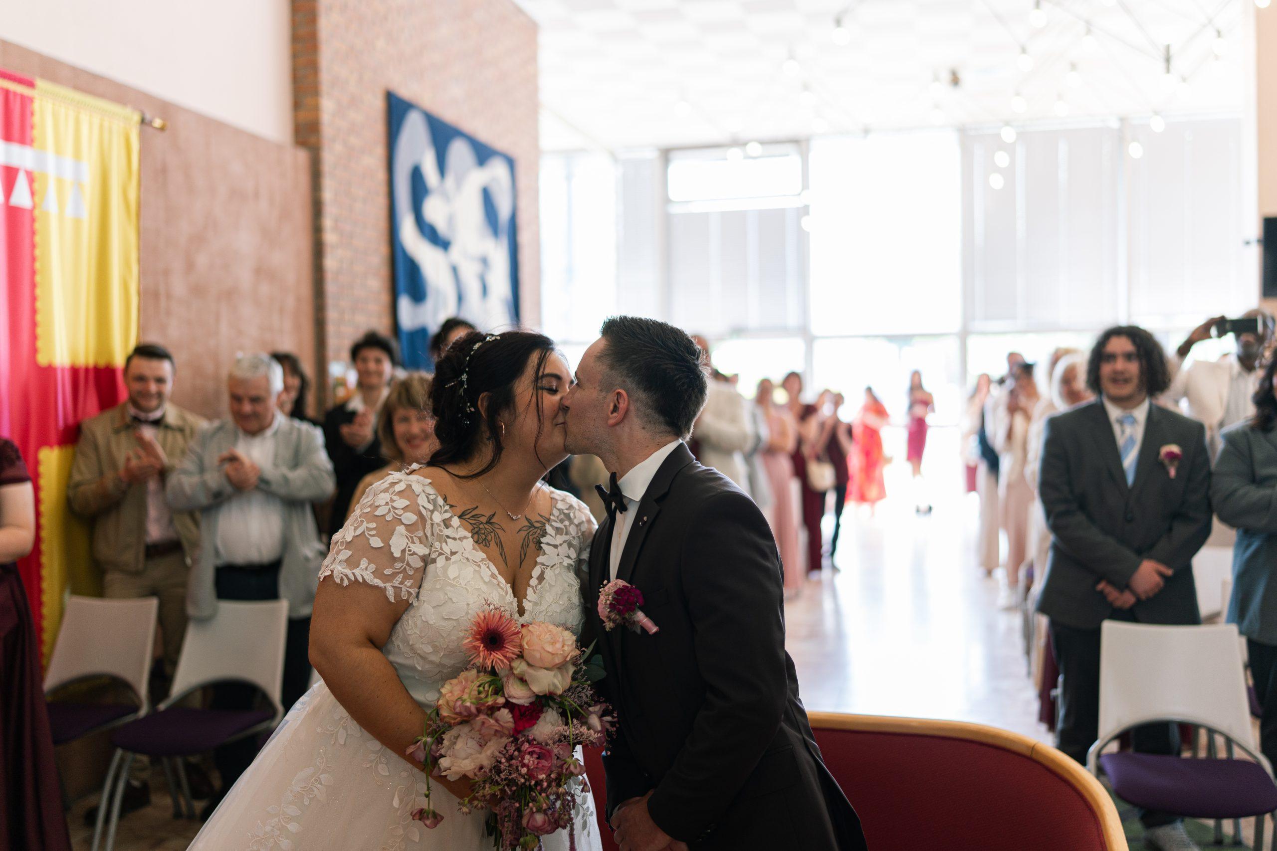 Émilie et Théo échangent un baiser entourés de leurs proches pendant leur mariage civil