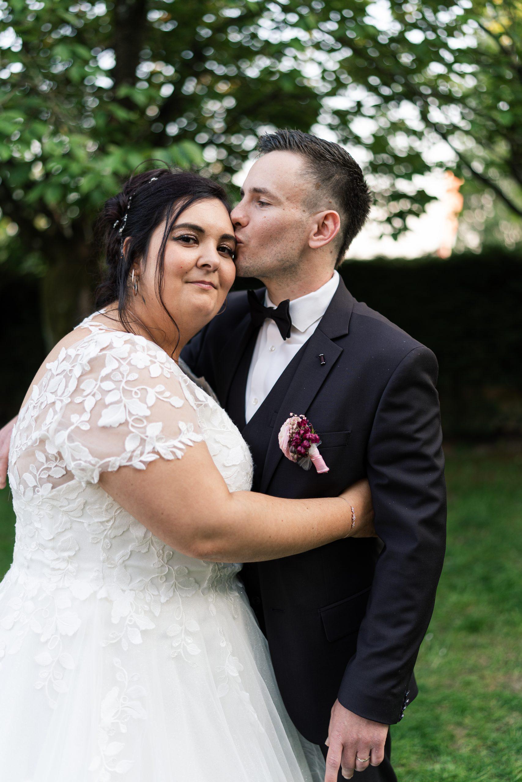 Théo embrasse Émilie sur le front pendant leur séance photo de couple