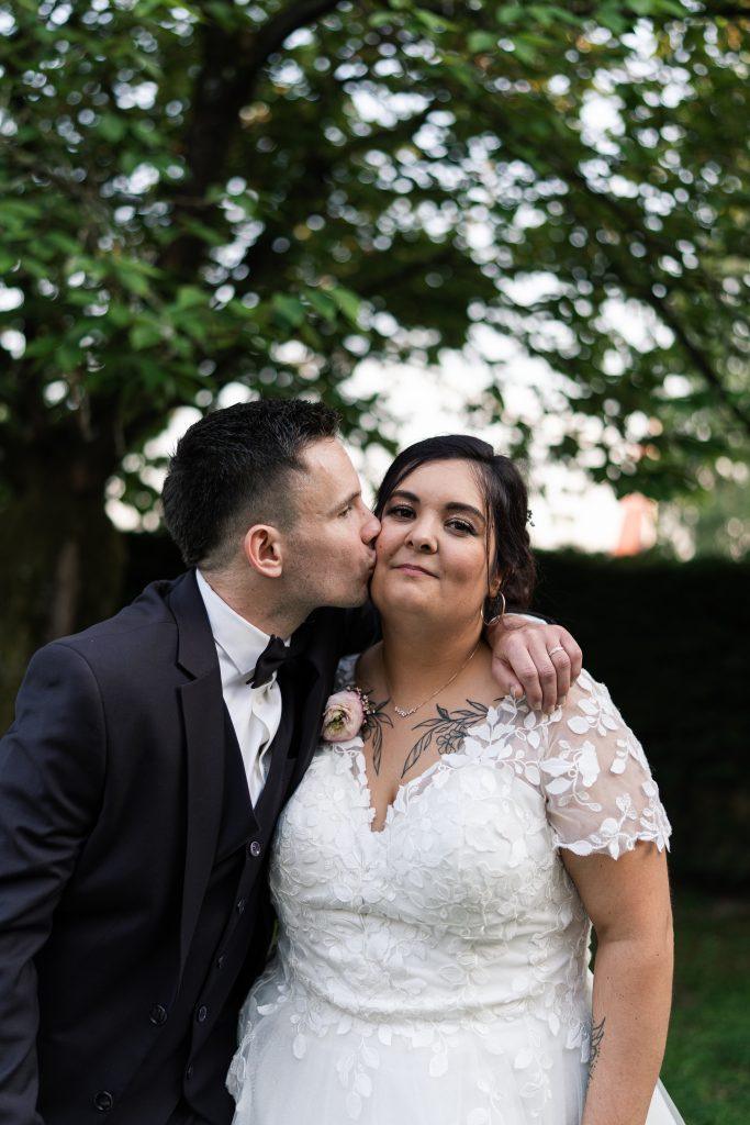 Théo embrasse Émilie sur la joue pendant leur séance photo de couple
