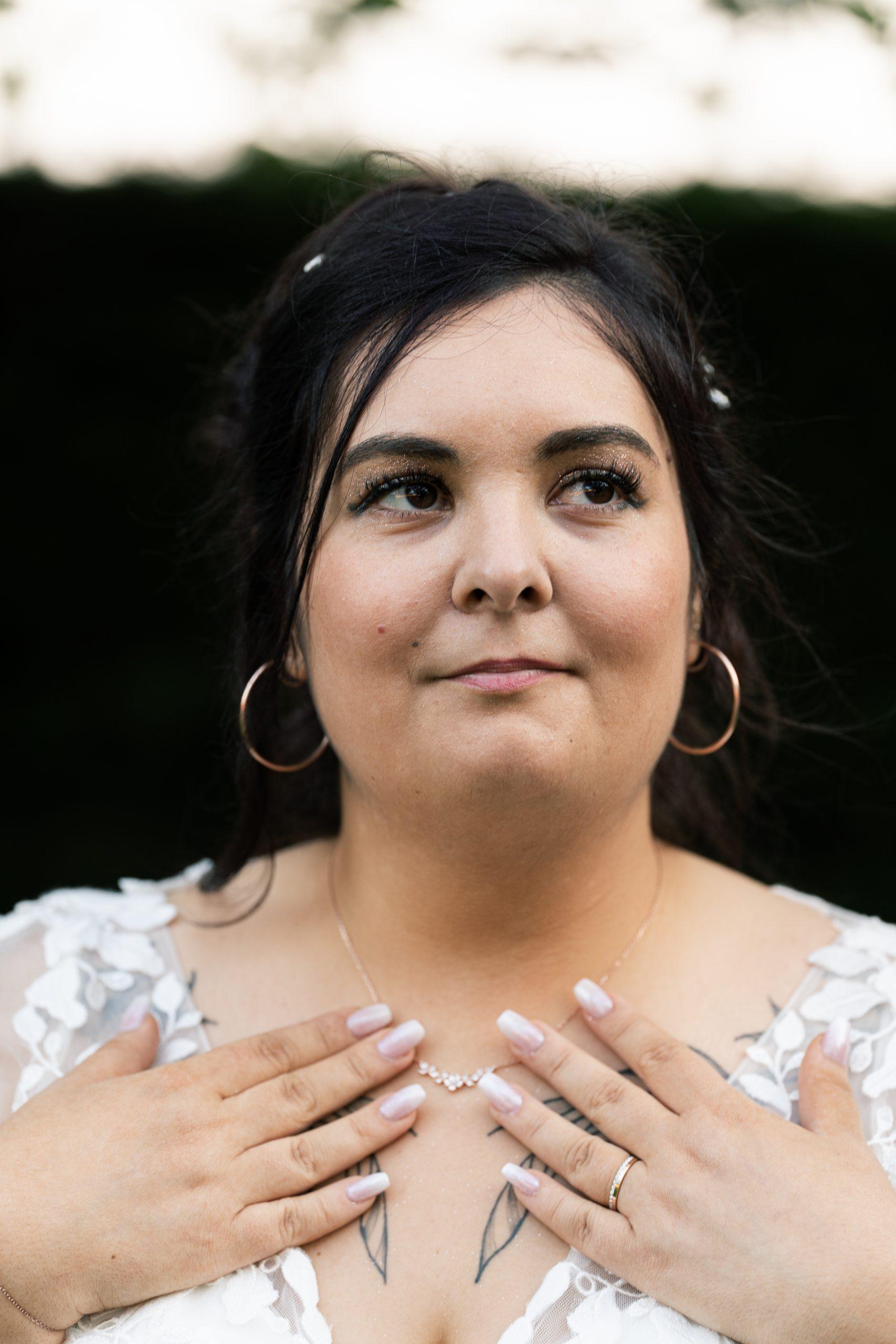 Émilie pose pour un portrait mettant en valeur sa robe et ses bijoux
